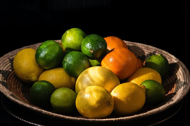 Neat fruit bowl full of limes, oranges and lemons