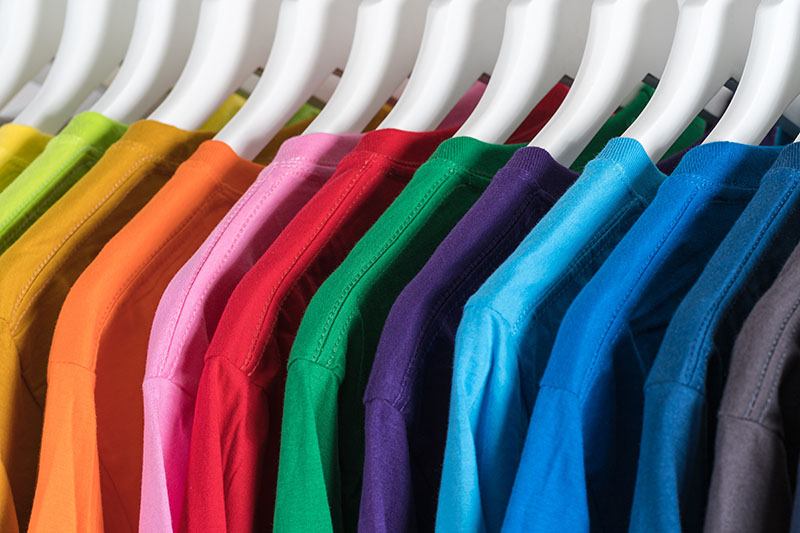 neatly ordered hanging T shirts sorted by colour