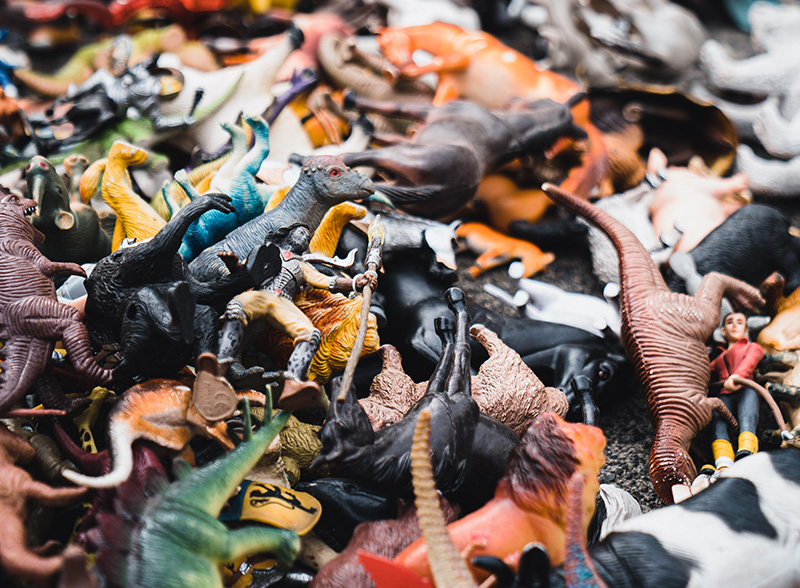 A closeup mess of plastic animals and dinosaurs. How to help children declutter