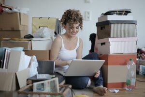 Decluttering tips for 2022, a lady surrounded by clutter