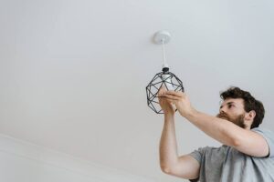 Household annoyances - man changes a light bulb