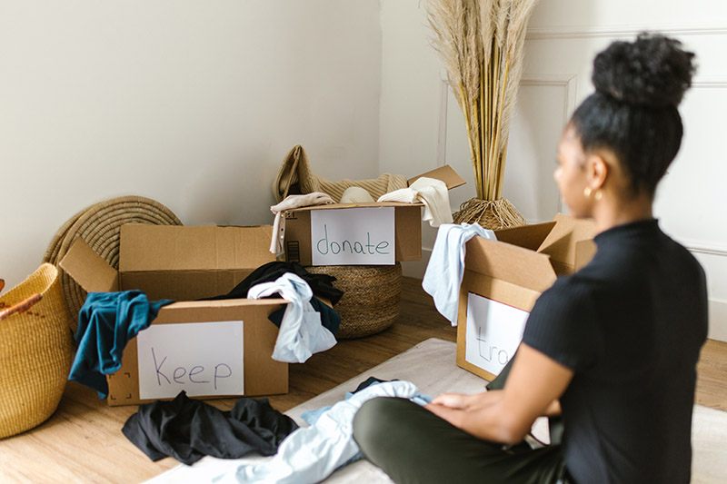 Decluttering Mistake - a lady contemplates 3 boxes of clothes